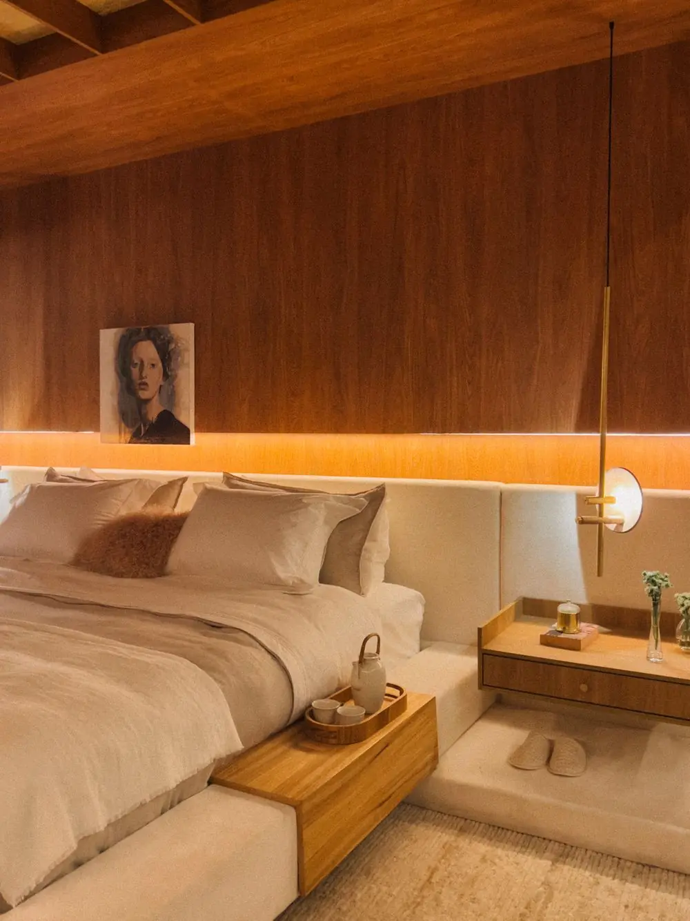Double bed against a warm wood-panelled wall