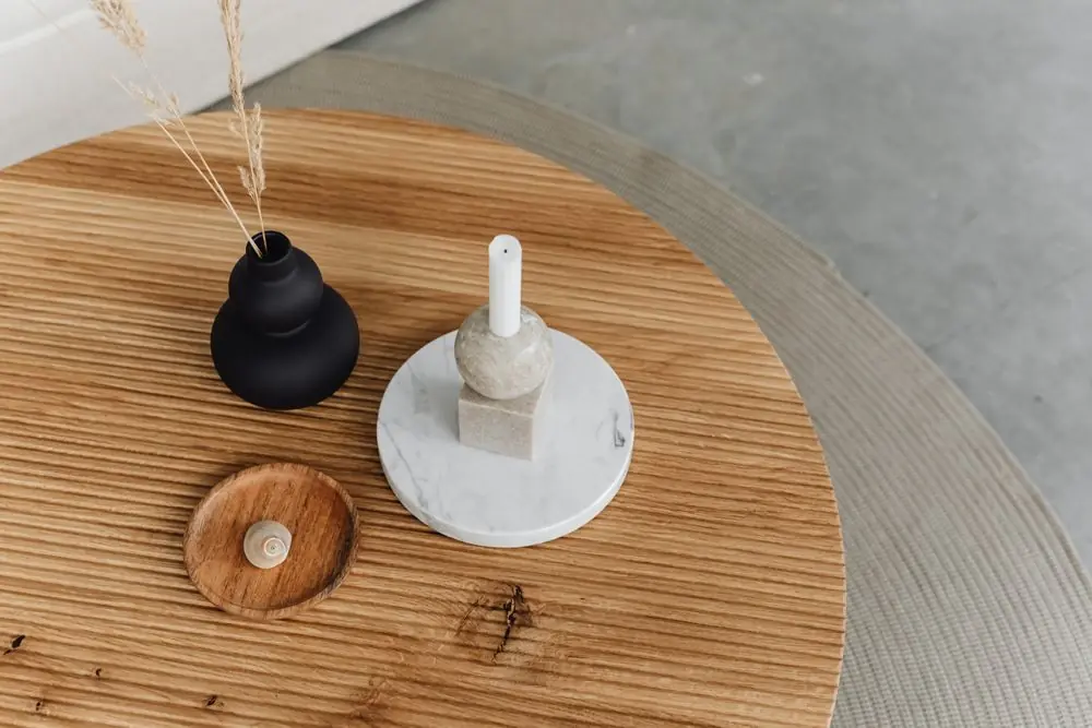 Round slatted wooden center table with ceramic objects