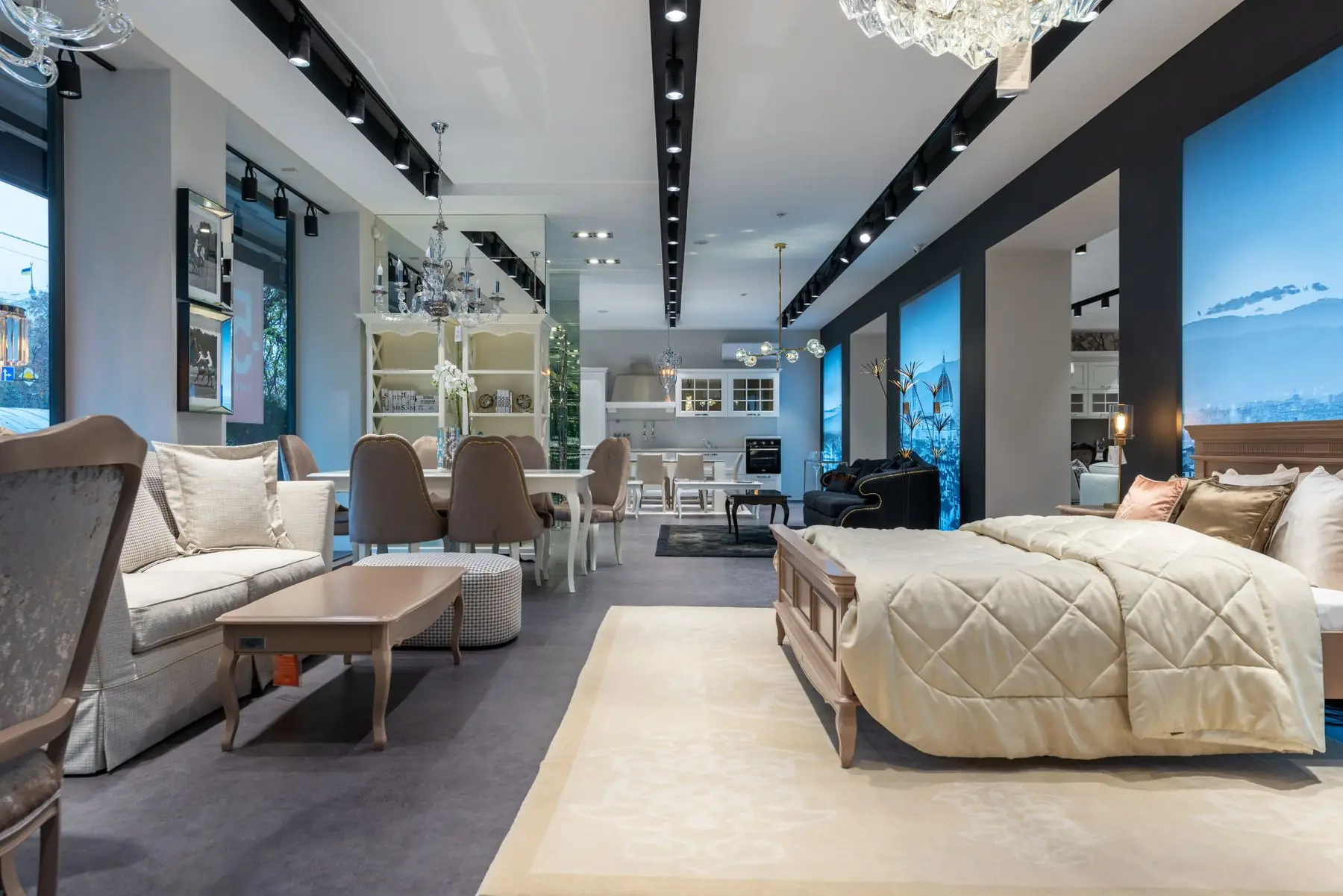 Showroom floor with sofas, a bed and dining sets under track lighting
